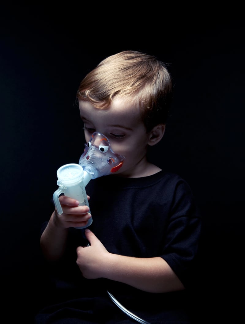 Young child using a breathing treatment machine shot by Los Angeles-based portrait photographer Kyle Monk for Cystic Fibrosis Foundation 