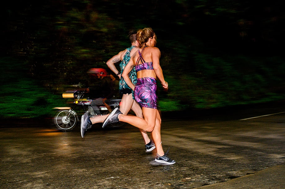 Ian MacLellans photo of male and female runners at night wearing brightly colored Janji apparel 