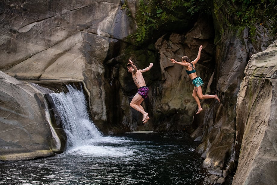 Ian MacLellans photo of runners wearing Janji jumping into water in front of a waterfall