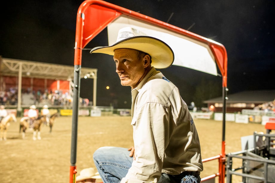 A man in a cowboy hat watches from the sidelines in this photo by Adam Hester