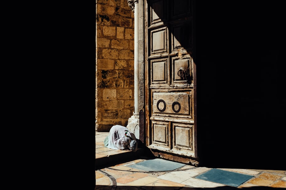 A Christian pilgrim prays at the entrance in this photo by David Vaaknan