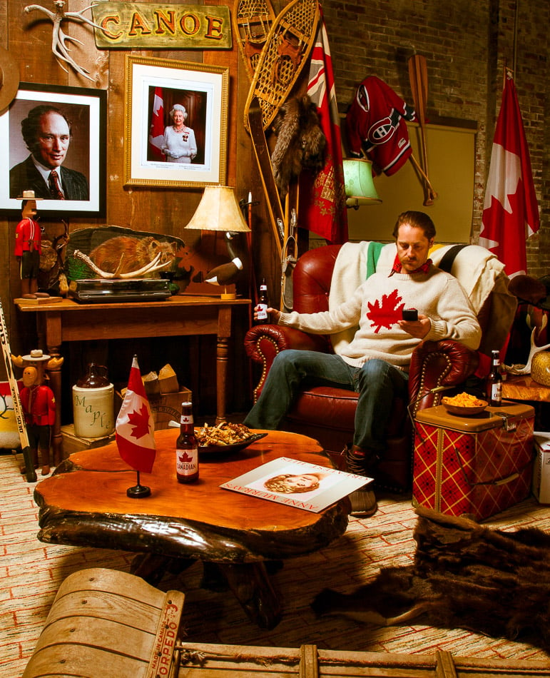 Man in Canadian sweater surrounded by Canadian-themed room shot by Vancouver-based photographer Kamil Bialous for Canadian business