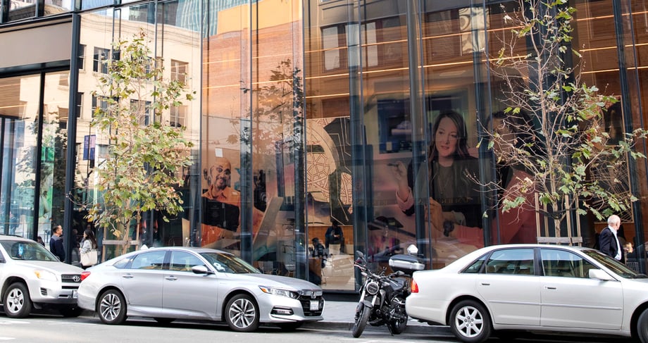 The same image by Sabrina Hill can be seen through the window facade of an office building in San Francisco