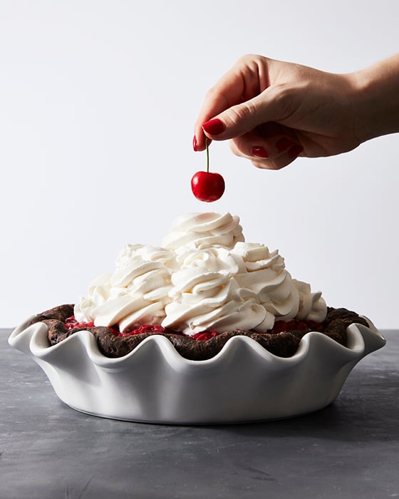 Mark Weinberg photographs someone plopping a cherry onto a beautiful pile of whip cream adorning a lovely chocolate pie