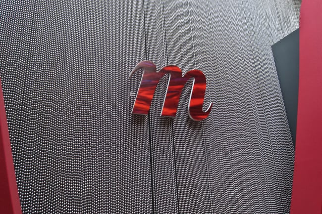 A red M logo on a gray wall of Momentum's lobby 