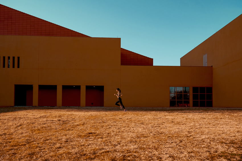 Photo of a woman jogging by a modern style building for a New Balance campaign with VML agency.