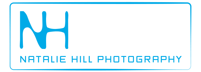 Natalie Hill's original logo showing her initials in blue text, connecting side by side followed by her name in boxy font. 