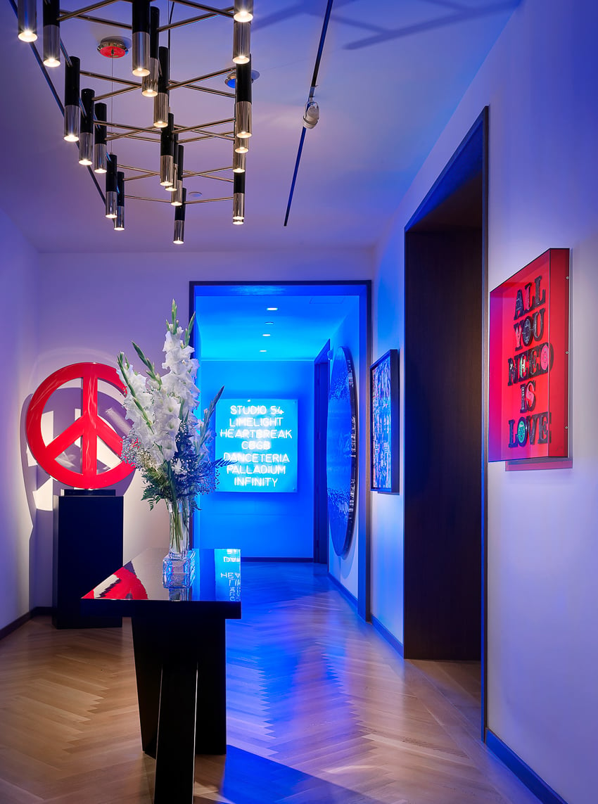 Photo of a hallway decorated with glowing neon signs for Pepe Calderin NYC.