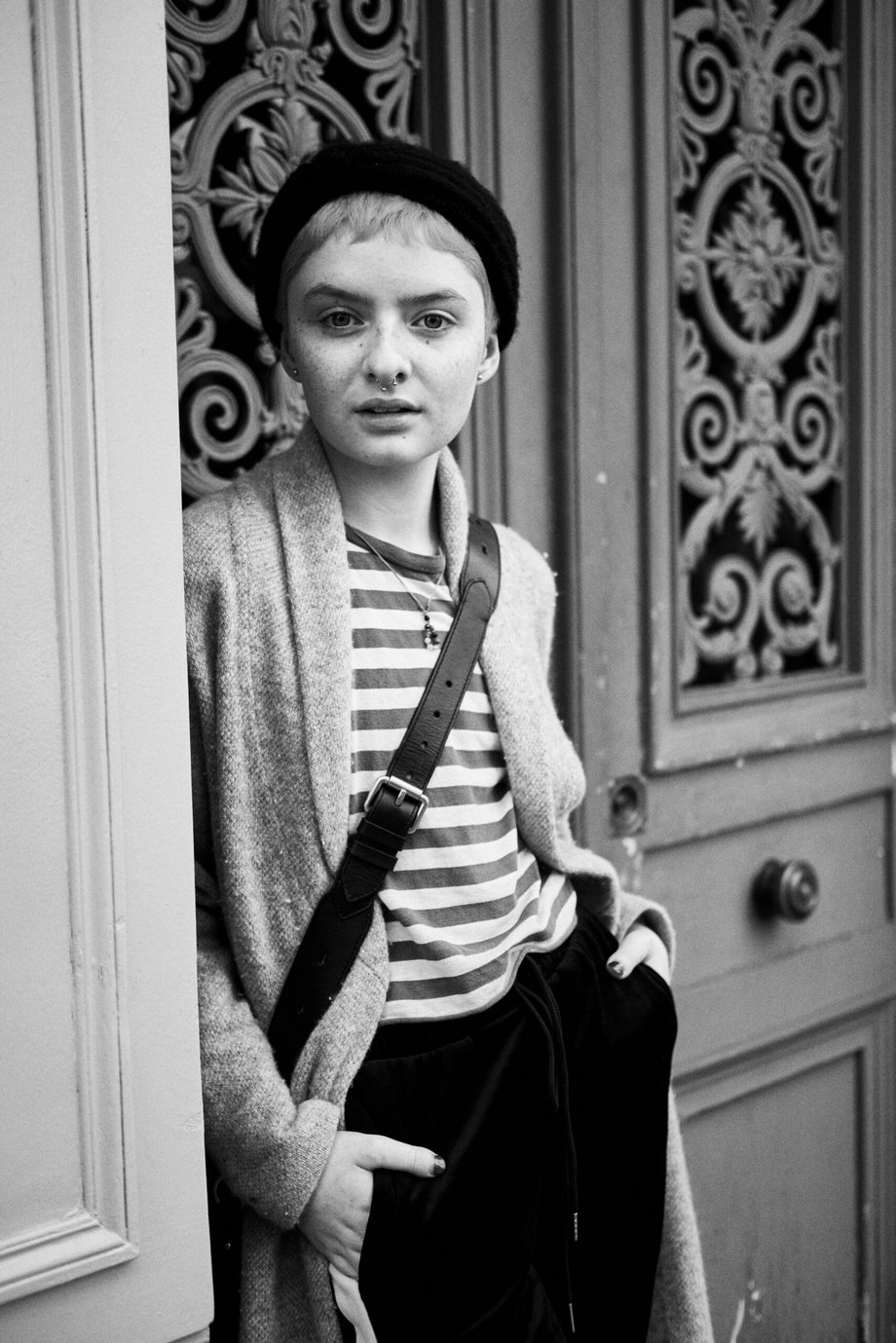 portrait of Lachlan Watson in a Parisian doorway wearing a striped shirt and beret