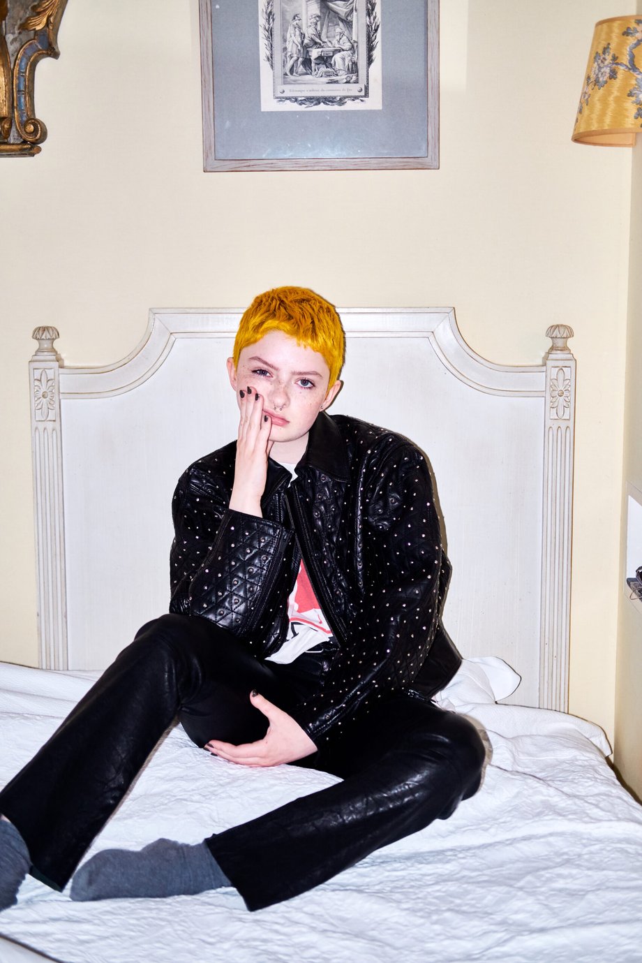 Jillian Clark's photo of Lachlan sitting on a bed in Paris, wearing a black studded jacket and black pants