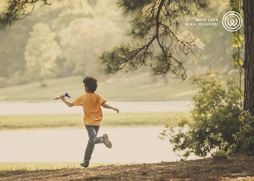 Portrait photo by Nate Luke of children running with toy airplane