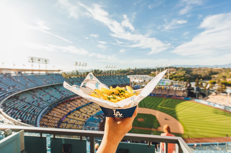 Krystal Thompson's photo of a hand holding up an order of fries overlooking Dodgers stadium on a sunny day.