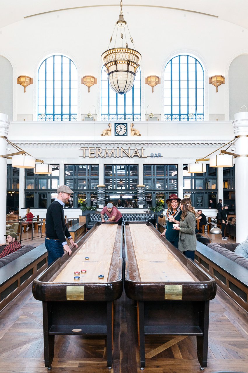 Rebecca Stumpf shoots several people playing shuffleboard outside of the Terminal Bar for Hemispheres