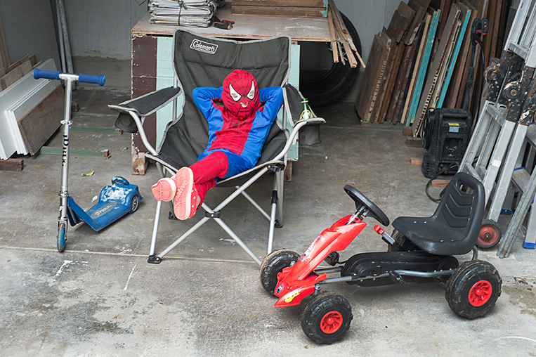 boy in a spiderman costume sitting in a chair