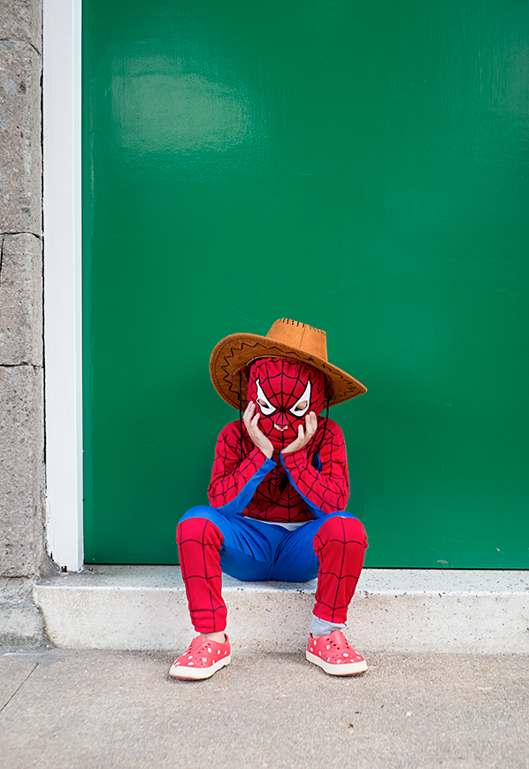 boy in a spiderman costume wearing a cowboy hat