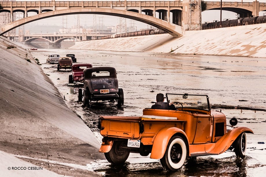 Hot rods lined up in a riverbed