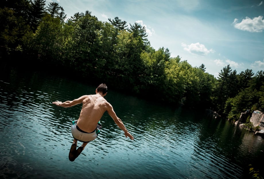 A young man jumps into a quarry in Boston, photo by Josh Andrus
