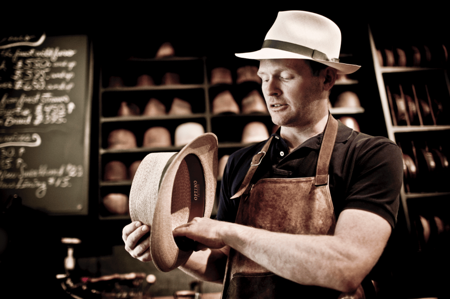 Photo by Tadd Myers of a craftsman showing the hats he makes.
