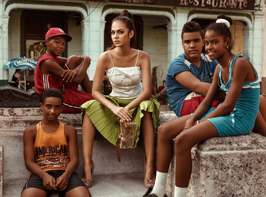 Photo by Clay Cook of a young woman sitting with four children.