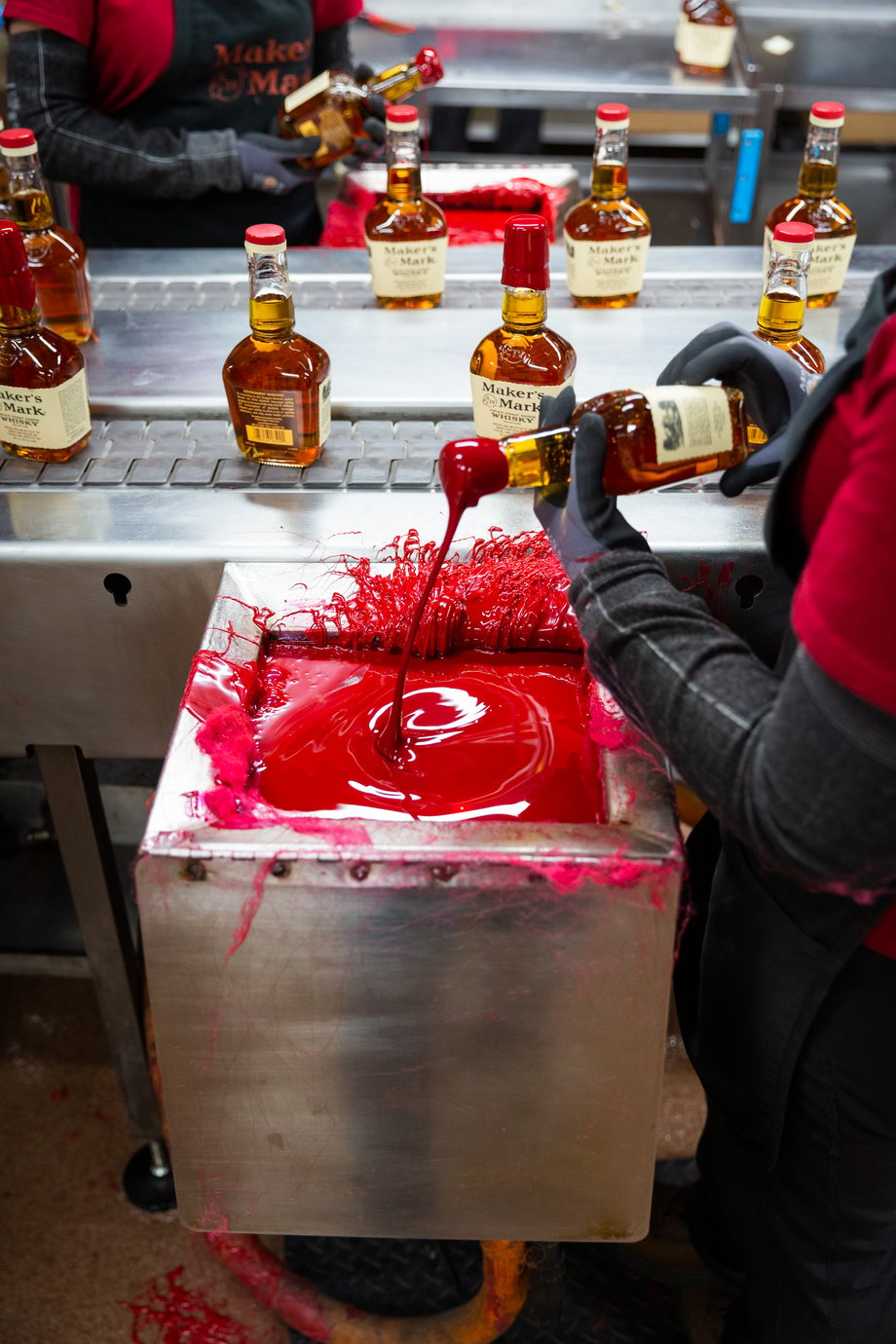 Matthew Allen captures a shot of Maker's Mark workers using red wax to seal bottle tops
