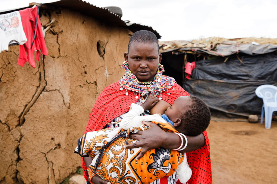 Tina Boyadjieva photographs a Kenyan mother in bright red and orange with all of her beads as she breastfeeds for Lansinoh USA