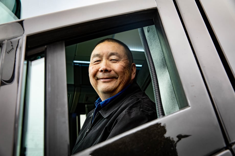 A bus operator looks out the window of his electric vehicle at Steve Boxall and smiles for the camera