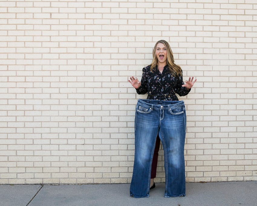 Photo by Victoria Wall Harris for Weight Watchers of Shana posing behind her old, larger sized jeans.