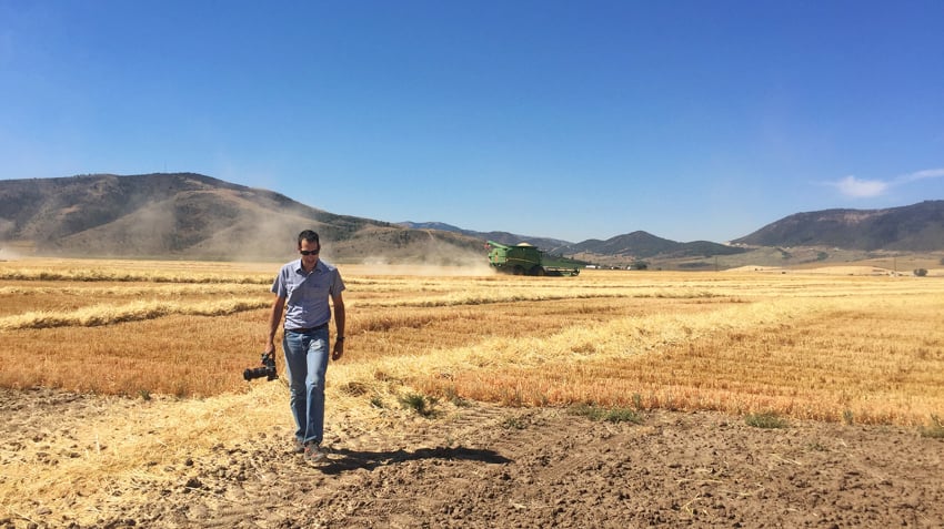 Photo of John Valls behind the scenes in a barley field.