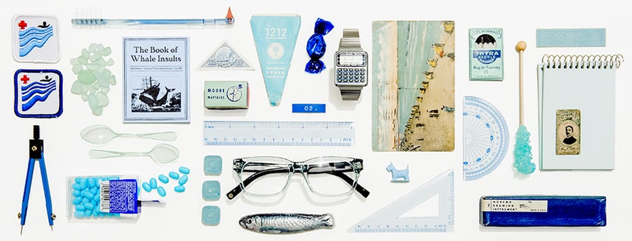 Tearsheet featuring clear glasses surrounded by other clear and blue objects, shot by New York-based still life photographer Greg Vore for Warby Parker
