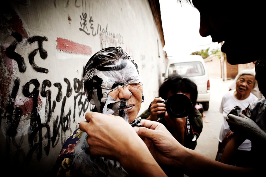 Liu Bolin removing paint from participate's face shot by Shanghai-based portrait photographer Zachary Bako 