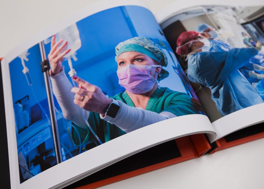 Image of the portfolio of Karen E. Segrave open to images of healthcare professionals in an operating room.