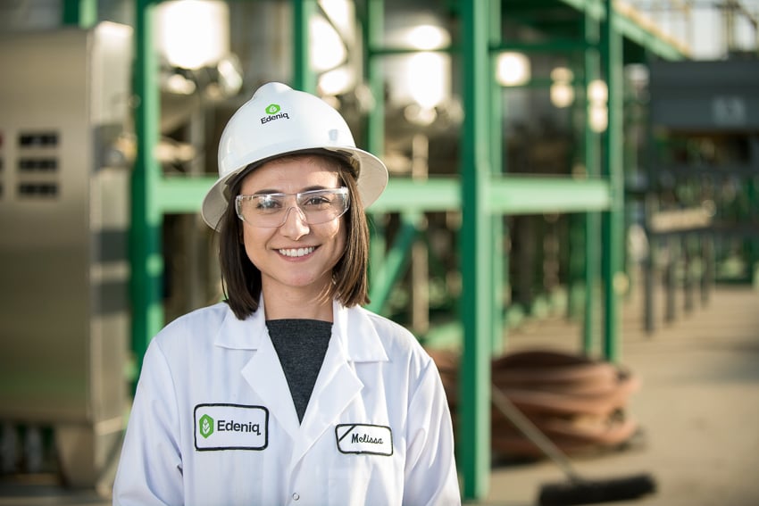 Photo of Melissa, Edeniq scientist in a lab coat and a hard hat.