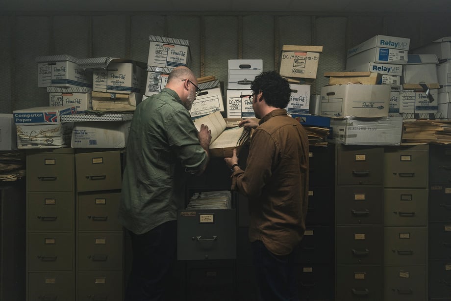 Fernando Decillis' photo of Chip and Andrew looking through files in front of a row of cabinets and storage