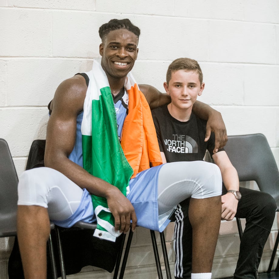 Aidan sits with an Irish flag around his neck and his arm draped around a young fan in this photo by Johnnie Izquierdo