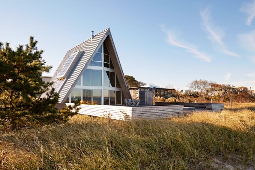 Photo of an A-frame house in a grassy field by A-Frame Studio's Ben Rahn.