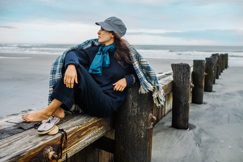 Portrait of woman sitting by beach by Photographer Aaron Greene