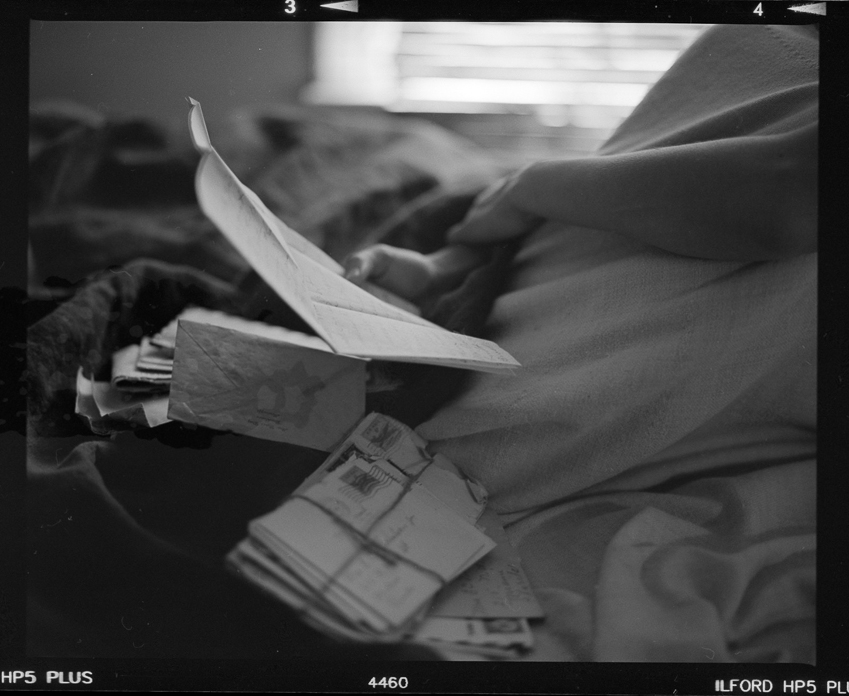 Black and white shot of woman holding papers on film by Photographer Aaron Greene for We Took to the Coast