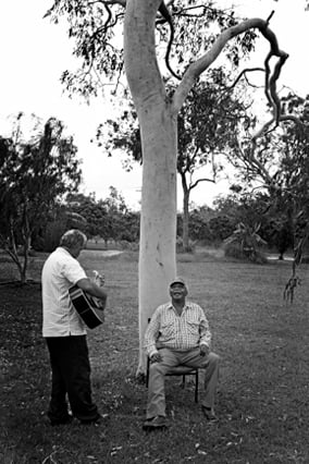 Lynton Crabb's black and white image of two men singing and playing guitar under a tree taken for Alzheimer's Australia.