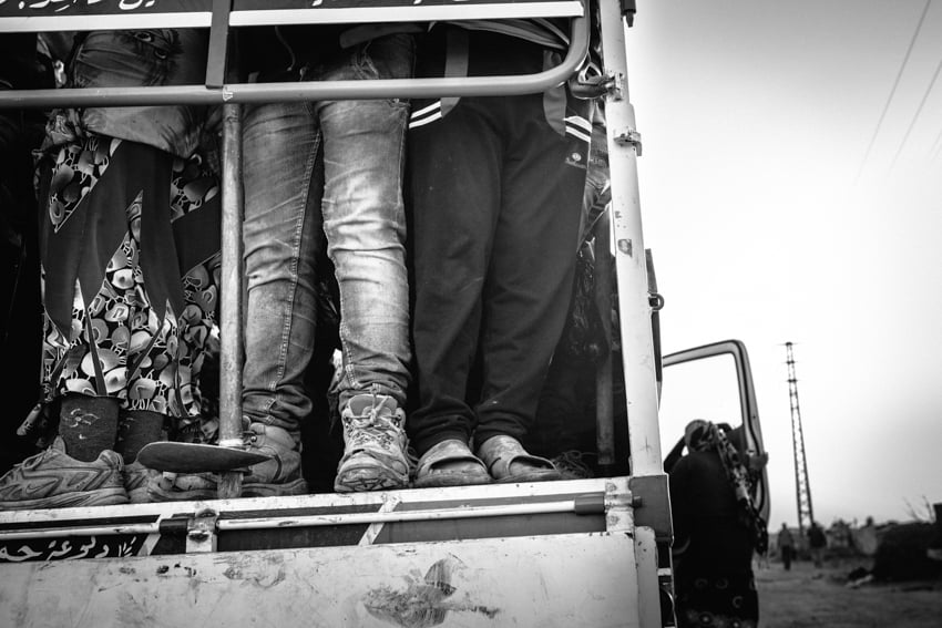 Syrian refugees in a truck taken to the Bekaa Valley potato fields photographed by Erol Gurian