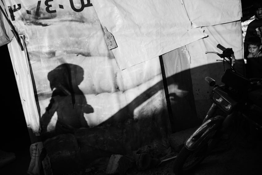 A shadow of a Syrian girl in a Bekaa Valley settlement photographed by Erol Gurian