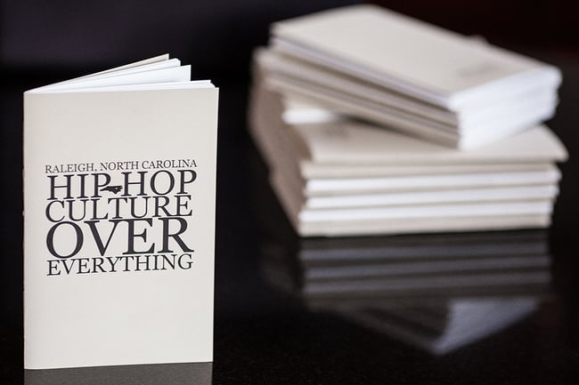 Image of the cover and a stack of booklets titled Raleigh, North Carolina Hip Hop Culture Over Everything.
