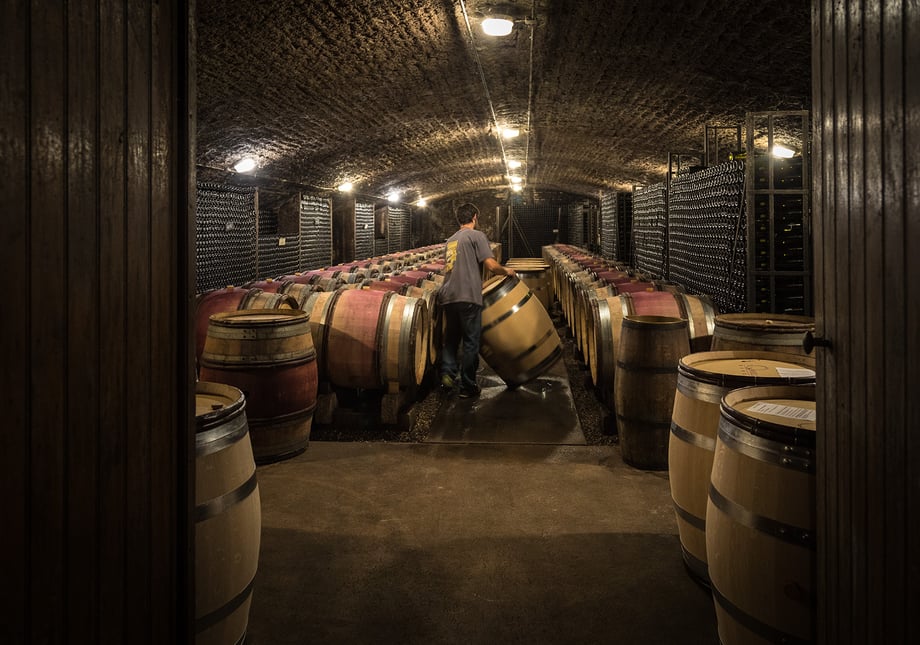 Photo of Domaine de Cromey barrels of wine in wine cellar shot by photographer Rocco Ceselin.