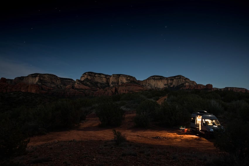 Night shot of a rocky plateau with light streaming from Scott Gable's camper van on trip The Big Scout