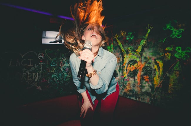 Hair flip at a karaoke bar shot by Philadelphia-based portrait photographer Chris Sembrot for Fuse