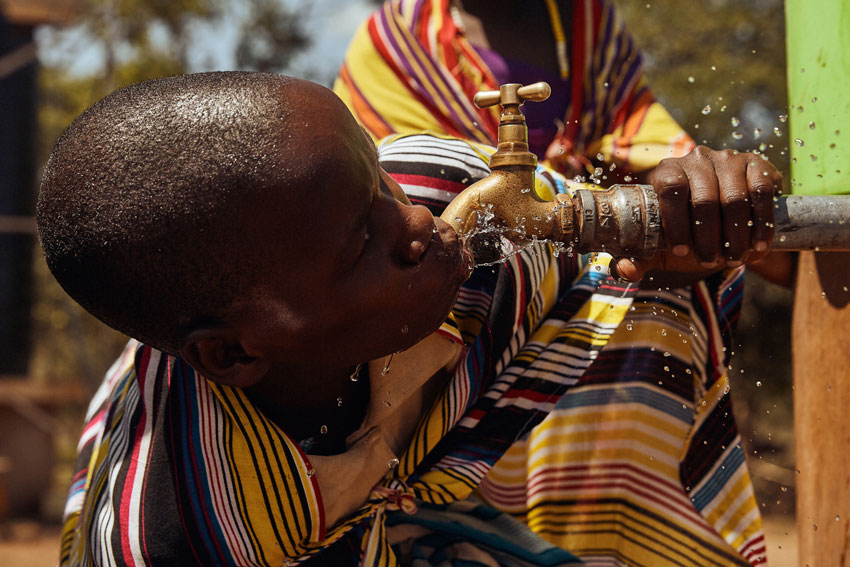 Clay Cook photographs a Maasai child drinking clean water symbolizing freedom.
