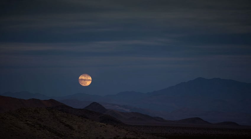 Scott Gable photographs a full moon over the mountains at night on trip The Big Scout
