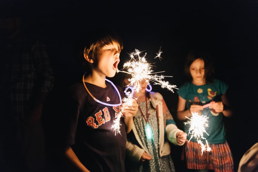 Photograph by Elizabeth Cecil of children holding sparklers.