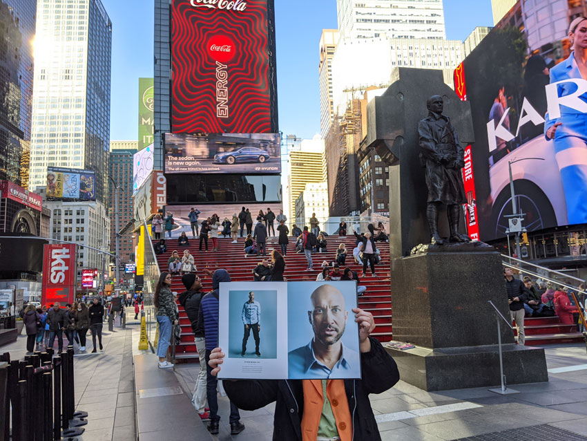Photo of Wonderful Machine's Natalia Martinez holding a picture of Keegan-Michael Key over her face in Time Square.