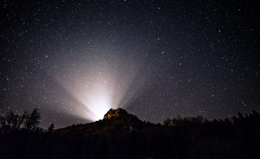 Photo of a light beam spread and the starry sky by Zurich photographer Frederik van den Berg