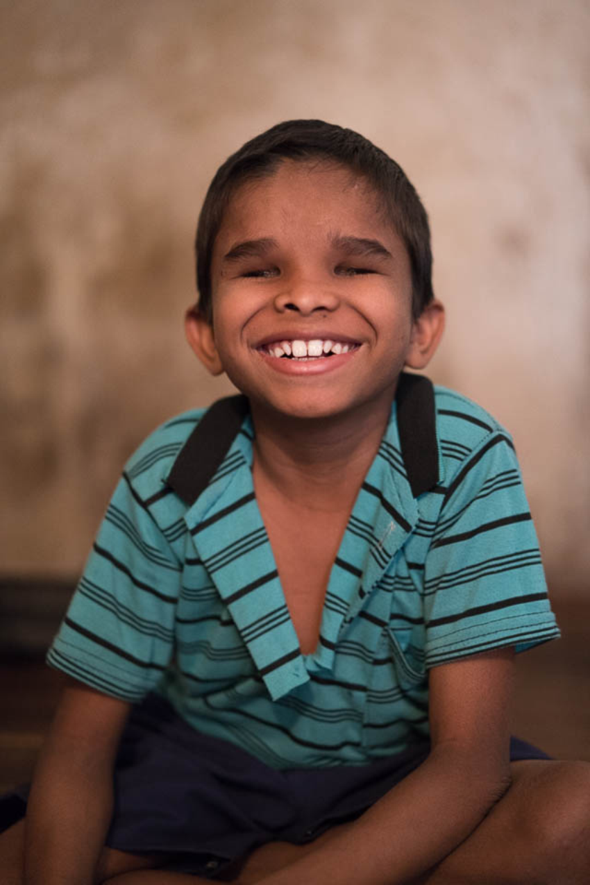 A young blind boy smiling wide, photo by Gary Chapman. 